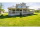 Charming two-story home showcasing a spacious wrap-around porch and lush green lawn at 9579 N Fortville Pike, Fortville, IN 46040
