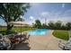 Outdoor pool with lounge chairs, mature trees, and fence at 9579 N Fortville Pike, Fortville, IN 46040