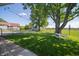 Expansive fenced yard with mature trees, picnic table, and string lights perfect for outdoor relaxation and entertainment at 9579 N Fortville Pike, Fortville, IN 46040