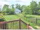 Expansive backyard view featuring a detached garage, surrounded by lush greenery and fencing at 9909 E Mcgregor Rd, Indianapolis, IN 46259