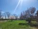 Expansive backyard featuring mature trees, lush green lawn, and a wooden fence, offering a serene outdoor space at 9909 E Mcgregor Rd, Indianapolis, IN 46259