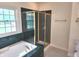 Bathroom featuring glass shower and tub with green marble at 9909 E Mcgregor Rd, Indianapolis, IN 46259