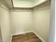 Empty closet with hardwood floors and overhead shelving, providing ample storage space and organizational potential at 9909 E Mcgregor Rd, Indianapolis, IN 46259