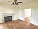 Spacious living room featuring a fireplace, a ceiling fan, and hardwood floors extending into an adjacent room at 9909 E Mcgregor Rd, Indianapolis, IN 46259