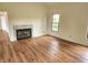Well-lit living room showcasing hardwood floors and fireplace, with a view into an adjacent room, filled with natural light at 9909 E Mcgregor Rd, Indianapolis, IN 46259