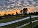Scenic view of the property featuring white fences and green pastures at sunset at 9909 E Mcgregor Rd, Indianapolis, IN 46259