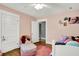Inviting pink bedroom with soft lighting, a cozy chair, and natural light at 1000 E King St, Franklin, IN 46131