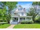 Charming two-story home featuring a large front porch, well-maintained lawn, and mature trees providing ample shade at 1000 E King St, Franklin, IN 46131