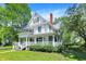 Traditional-style home with a charming white exterior, covered porch, and beautifully landscaped front yard at 1000 E King St, Franklin, IN 46131