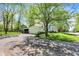 Exterior view of a white home with an attached garage, lush lawn and mature trees at 1000 E King St, Franklin, IN 46131