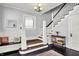 Inviting foyer with hardwood floors, staircase, and a decorative bench, creating a warm and welcoming entrance at 1000 E King St, Franklin, IN 46131