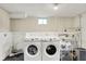 A laundry room with a side-by-side washer and dryer, along with a utility sink and ample storage options at 1000 E King St, Franklin, IN 46131