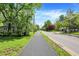 A well-maintained sidewalk lined with lush green trees and grassy lawns, creating a peaceful residential area at 1000 E King St, Franklin, IN 46131