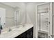 Bathroom featuring a double vanity with white countertops, a large mirror, and a glass-enclosed shower at 10236 Arctic Edge Dr, Indianapolis, IN 46239