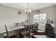 Bright dining room with a large table, modern chandelier, dark wood floors, and a bar against the wall at 10236 Arctic Edge Dr, Indianapolis, IN 46239