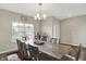 Bright dining room with a large table, modern chandelier, dark wood floors, and a bar against the wall at 10236 Arctic Edge Dr, Indianapolis, IN 46239