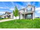 Inviting two-story home with a manicured lawn and young tree, gray siding, black brick, and an attached two-car garage at 10236 Arctic Edge Dr, Indianapolis, IN 46239