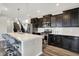 Modern kitchen with stainless steel appliances, a large island, dark cabinets, and hardwood floors, creating a welcoming space at 10236 Arctic Edge Dr, Indianapolis, IN 46239