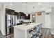 Modern kitchen with stainless steel appliances, dark wood cabinets, and a spacious quartz island at 10236 Arctic Edge Dr, Indianapolis, IN 46239