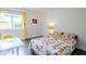 Bright bedroom with floral bedding, desk, and window with bright yellow curtain and wood plank flooring at 1046 Timber Creek Dr # 3, Carmel, IN 46032