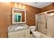 Bathroom with granite vanity, white fixtures, and a shower-tub combination with glass door for a practical and stylish space at 10713 Stable Dr, Indianapolis, IN 46239