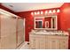 Bright bathroom featuring a double sink vanity with granite countertop, a glass door shower, and vibrant red walls at 10713 Stable Dr, Indianapolis, IN 46239