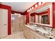 Bathroom features a double sink vanity with granite countertops, shower and red walls at 10713 Stable Dr, Indianapolis, IN 46239
