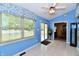 Bright Florida room with blue walls, ceiling fan, and view of the backyard at 10713 Stable Dr, Indianapolis, IN 46239