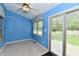 Florida room with blue walls, ceiling fan, sliding door and access to backyard at 10713 Stable Dr, Indianapolis, IN 46239