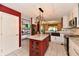 Renovated kitchen boasting granite countertops, a red island, stainless appliances and white cabinets at 10713 Stable Dr, Indianapolis, IN 46239