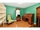 Cozy office space featuring a classic roll-top desk, built-in shelving, and a comfortable green chair for a productive work area at 10713 Stable Dr, Indianapolis, IN 46239