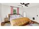 Bright bedroom featuring hardwood floors, a ceiling fan, colorful bedding, and a window at 1124 E 35Th St, Indianapolis, IN 46205