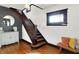 Open foyer featuring hardwood floors, staircase, wood trim, bench and wall accents at 1124 E 35Th St, Indianapolis, IN 46205