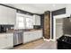 Modern kitchen with stainless steel appliances, granite countertops, white cabinets, and a brick column at 1124 E 35Th St, Indianapolis, IN 46205