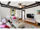 Comfortable living room featuring hardwood floors, coffered ceilings, modern TV, and cozy seating at 1124 E 35Th St, Indianapolis, IN 46205