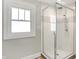 Modern glass-enclosed shower with white subway tiles and a window at 1124 E 35Th St, Indianapolis, IN 46205