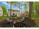 Landscaped backyard featuring mature trees, fire pit area, and play structure at 11243 Catalina Dr, Fishers, IN 46038