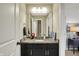 Bathroom with a granite countertop vanity, dark cabinets, and a decorative mirror at 11323 Still Creek Dr, Zionsville, IN 46077
