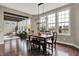 Bright dining room with dark wood floors, large windows, modern lighting, and open floor plan into the living room at 11323 Still Creek Dr, Zionsville, IN 46077