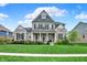 Charming two-story home with brick and stone exterior, lush lawn, and well-manicured landscaping at 11323 Still Creek Dr, Zionsville, IN 46077