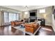 Cozy living room with leather sofas, fireplace, and large windows for abundant natural light at 11323 Still Creek Dr, Zionsville, IN 46077