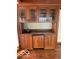Wooden wet bar featuring glass cabinets, a sink, and a built-in refrigerator with a light countertop at 1138 E 58Th St, Indianapolis, IN 46220