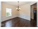 Elegant dining room featuring hardwood floors, wainscoting, a classic chandelier, and neutral paint at 11473 Rainbow Falls Ln, Fishers, IN 46037