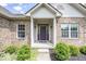 Inviting front entrance with a charming wreath on the purple door and decorative plants at 11473 Rainbow Falls Ln, Fishers, IN 46037