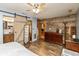 Bedroom featuring wood floors, closet, adjacent bathroom, and rustic wood accent wall at 1157 Fielding Ln, Franklin, IN 46131