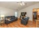 Comfortable living room with hardwood floors, black leather furniture, fireplace, and ceiling fan at 1157 Fielding Ln, Franklin, IN 46131