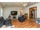 Comfortable living room with hardwood floors, black leather furniture, fireplace, and ceiling fan at 1157 Fielding Ln, Franklin, IN 46131