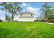 Rear view of farmhouse-style house, surrounded by a grassy field and various vehicles at 1170 E 400 S, Lebanon, IN 46052
