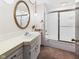 Bathroom with white vanity, gold framed mirror, tub with sliding glass doors at 1209 S Rangeline Rd, Anderson, IN 46012