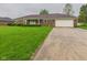 Charming brick home featuring a long driveway and meticulously maintained front lawn with lush shrubbery at 1209 S Rangeline Rd, Anderson, IN 46012